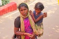 India, GOA, January 28, 2018. Poor woman with a child asks for money on the street in India. A beggar woman with an outstretched