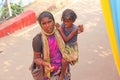 India, GOA, January 28, 2018. Poor woman with a child asks for money on the street in India. A beggar woman with an outstretched