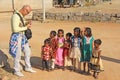 India, Hampi, 02 February 2018. A bald and cheerful European man gives gifts to Indian children. Joyful children are pulling their