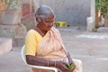 India, Hampi, February 2, 2018. An elderly Indian woman in a sari sits on a chair