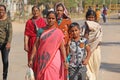 India, Hampi, February 2, 2018. A group of people, men and women in the saris, walk along the street of Hampi village. Hampi,
