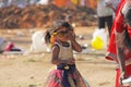 India, Hampi, 02 February 2018. A small poor and dirty Indian girl playing with sunglasses. A little girl in big glasses from the