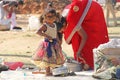 India, Hampi, 02 February 2018. A small poor and dirty Indian girl playing with sunglasses. A little girl in big glasses from the