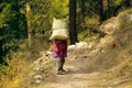 Mountaineer woman with a heavy bag on a mountain path