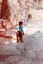 Indian boy is resting in shade on old pavement