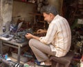 Master of repair of sewing machines in his workshop