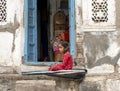 india Jodhpur 03 25 2023 a little girl plays sitting in front of the door of the house