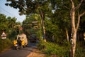 A typical road in an Indian village. Auto rickshaw, truck and motorcycle among tropical greenery a Royalty Free Stock Photo