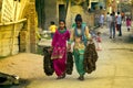 Indian girls carry specific fuel for stoves made of cow cakes