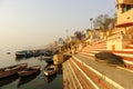 India, Varanasi Ganges river ghat with ancient city architecture as viewed from a boat on the river at sunset