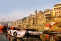 India, Varanasi Ganges river ghat with ancient city architecture as viewed from a boat on the river at sunset