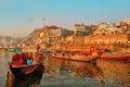 India, Varanasi Ganges river ghat with ancient city architecture as viewed from a boat on the river at sunset