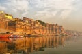 India, Varanasi Ganges river ghat with ancient city architecture as viewed from a boat on the river at sunset
