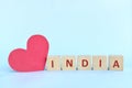 India word on wooden blocks with red heart shape cutout in blue background. Support, sympathy and send love to India concept. Royalty Free Stock Photo