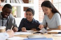 Indian, african, asian classmates do school assignment together indoors