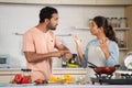 Indian Angry Husband arguing with wife while cooking at kitchen due to hungry - concept of family problems, relationship Royalty Free Stock Photo