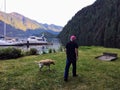 A man on summer boating trip, walking his dog along the ocean front in the beautiful remote location of Indian Arm Royalty Free Stock Photo