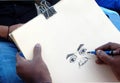 Indian artist drawing with pencil on a paper a portrait of man