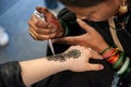 Tattooing with henna mixture, in the street