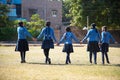 Indian asian happy school girls holding hands and walking playing in a garden wearing school uniform