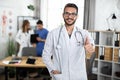Indian Asian male doctor in a clinic room, showing thumb up and smiling to camera Royalty Free Stock Photo