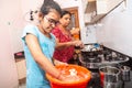 Indian/Asian Mother and Daughter working in kitchen, Young Girl kneading flour, learn to cook Due to lock down