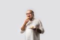 Indian asian Senior man or old man eating Samosa snack