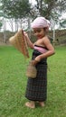 Indian Assamese baby girl in traditional costume with fishing equipment.