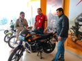 an indian automobile salesmen presenting bike model to the couple customer at showroom in India January 2020