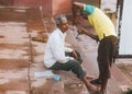 The Indian barber shaves a Hindu pilgrim on the ghats. Life along the Ganges Ganga river in the morning in Varanasi.