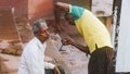 The Indian barber shaves a Hindu pilgrim on the ghats. Life along the Ganges Ganga river in the morning in Varanasi.