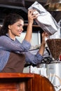 Indian barista filling coffee grinder Royalty Free Stock Photo