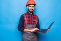 Indian beard repairman using laptop isolated on blue background