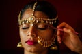 Indian beautiful female in golden rich jewelery and tradition saree face closeup professional make-up wearing bindi on Royalty Free Stock Photo