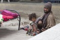 Indian beggar man with children on the street in Leh, Ladakh. India Royalty Free Stock Photo