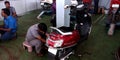 indian bike mechanic repairing motorcycle at bajaj service center in India aug 2019