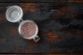 Indian Black salt, Kala namak hindi Healthy food concept, in glass jar, on old dark wooden table background, top view flat lay ,