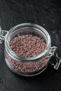 Indian Black salt, Kala namak hindi Healthy food concept, in glass jar, on black stone background Royalty Free Stock Photo