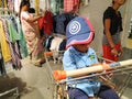 Indian Blue Shirt Wear little Kid in a Big Bazaar Sitting in a Trolley with Cap