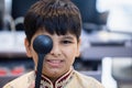 Indian boy examining eyesight checkup vision farsightedness examines ophthalmological hospital. doctor using occluder for eye