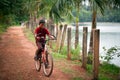 Indian boy riding bicycle near lake