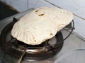 Indian bread,Roti, being blown over oven Royalty Free Stock Photo