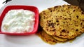 Indian breakfast dish.Stuffed potato paratha or channa dal paratha served with curd. Selective focus