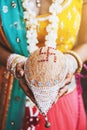 Indian bride with bangles on her wrist holding coconut shagun nariyal for indian marriage ritual Royalty Free Stock Photo