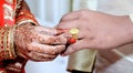 Indian Bride putting a wedding ring on groom`s finger Royalty Free Stock Photo