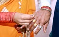 Indian Bride putting a wedding ring on groom`s finger Royalty Free Stock Photo