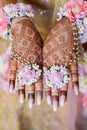 Indian bride\'s hands are decorated with henna flowers and designs in Indian traditional style