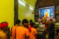 Indian Buddhist monk and people standing and praying on bare foot in front of large statue of lord Buddha inside Mahabodhi Temple. Royalty Free Stock Photo