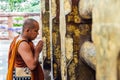 Indian Buddhist monk standing and praying in front of The Bodhi Tree near Mahabodhi Temple at Bodh Gaya, Bihar, India