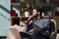 Indian business man executive looking away sitting on chair in modern office. Royalty Free Stock Photo